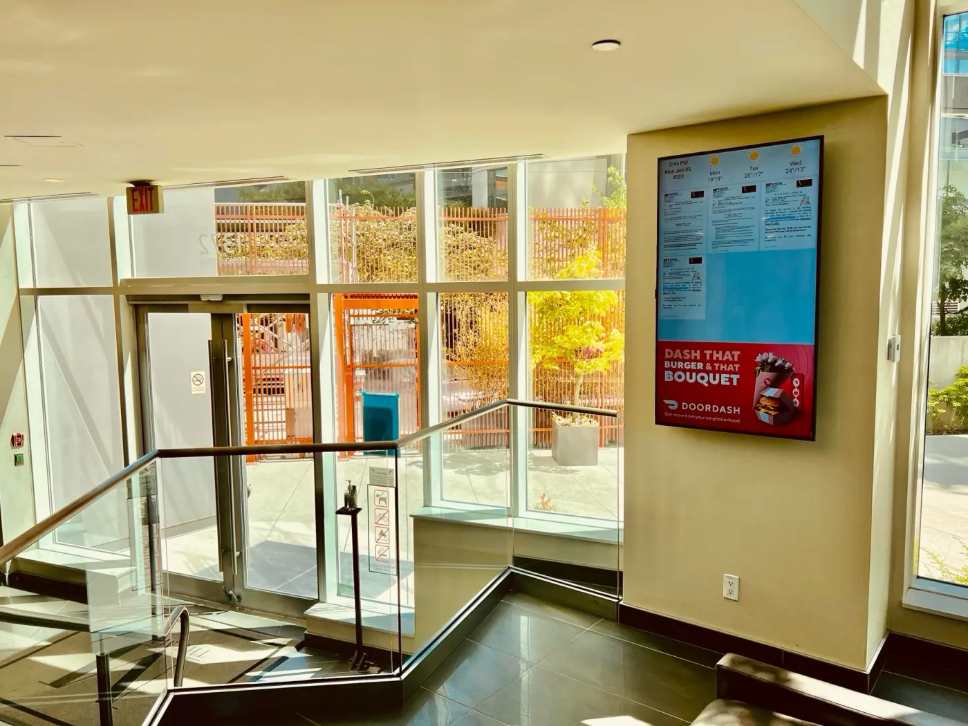 Emplace screen in a residential building lobby showing DoorDash ad